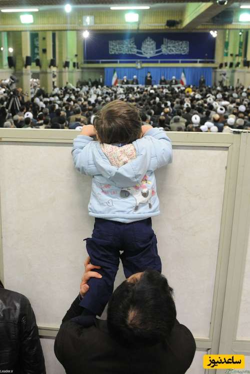 تلاش خنده دار یک کودک در بالا رفتن از دَر برای دیدن رهبر معظم انقلاب+عکس /ای جانم...